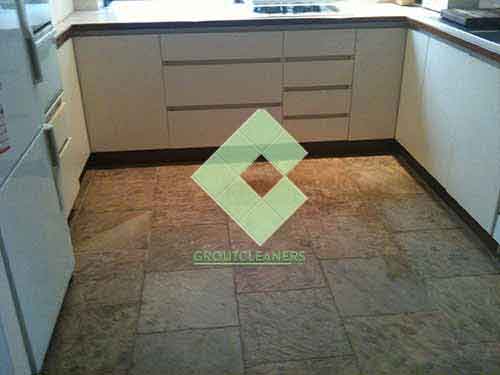 unsleaed_clean_slate_tiles_in_kitchen_floor_with_white_cupboards