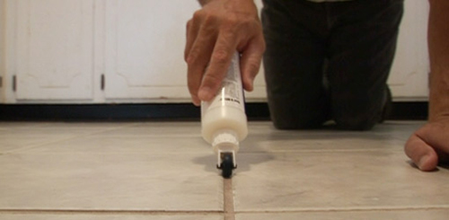 man sealing grout tile floors using best products