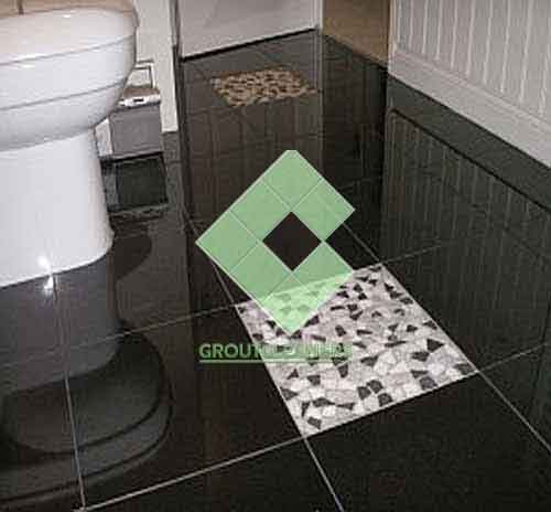 polished_granite_tile_floor_in_bathroom_black_with_one_white_tile